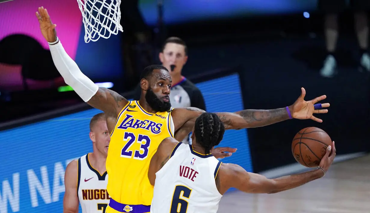 Pebasket Los Angeles Lakers, LeBron James, berusaha menghadang pemain Denver Nuggets, Keita Bates-Diop, pada laga NBA di The Arena, Senin (11/8/2020). LA Lakers menang dengan skor 124-121. (AP Photo/Ashley Landis, Pool)