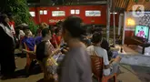 Sejumlah warga kawasan Menteng Jaya menyaksikan pertandingan sepak bola antara Timnas Indonesia melawan Bahrain pada laga Kualifikasi Piala Dunia 2026 putaran ketiga Zona Asia yang digelar di Stadion Utama Gelora Bung Karno, Jakarta, Selasa (25/3/2025). (Liputan6.com/Herman Zakharia)