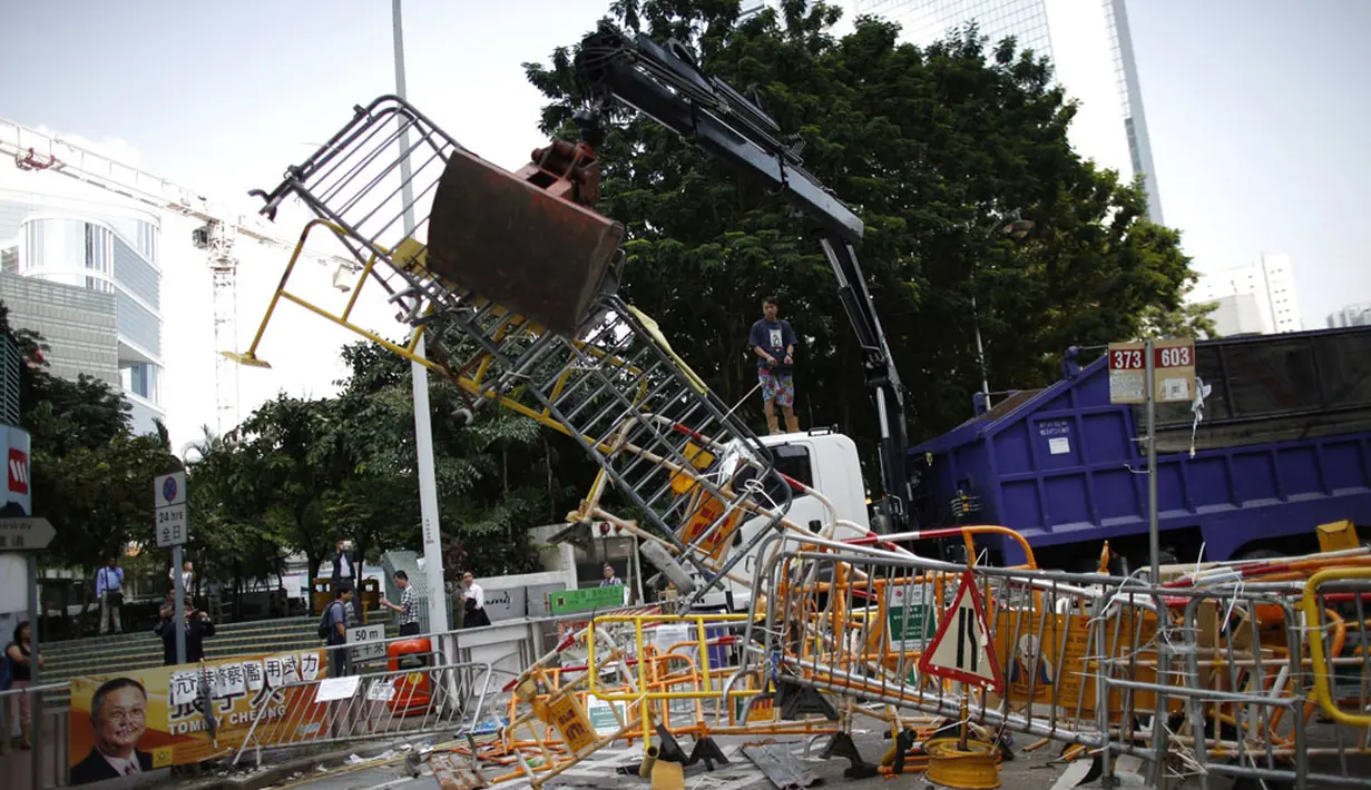 Mobil derek mengangkut barikade penutup lokasi utama berlangsungnya aksi demonstasi massa pro-demokrasi di Admiralty, Hong Kong, (13/10/2014). (REUTERS/Carlos Barria)