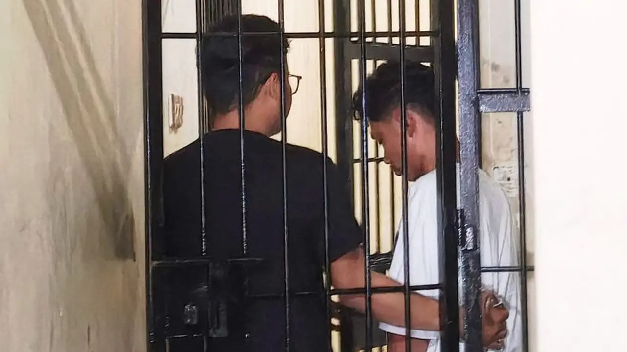 Penyidik menggiring tersangka inisial SHM (kanan) masuk ke dalam sel tahanan usai diinterogasi di ruang penyidik Polsek Tamalare, Makassar, Sulawesi Selatan, Senin (15/6/2026) malam (Istimewa)