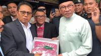 Penjabat Gubernur Gorontalo Hamka Hendra Noer menyerahkan cinderamata Karawo kepada Perdana Menteri Malaysia Dato' Seri Anwar Ibrahim, Jumat (14/1/2023).