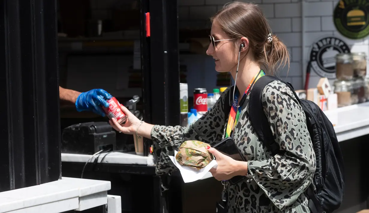Seorang wanita membeli makanan di sebuah kios di Pasar Camden di London, Inggris, pada 2 Juni 2020. Perdana Menteri Inggris Boris Johnson pada 28 Mei mengumumkan beberapa langkah pelonggaran kebijakan lockdown yang "terbatas" dan "hati-hati" di negaranya. (Xinhua/Ray Tang)