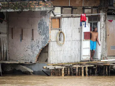 Warga permukiman bantaran Sungai Ciliwung menyaksikan banjir, Jakarta, Senin (10/10/2022). Hingga pukul 09.00 WIB hari ini, Badan Penanggulangan Bencana Daerah (BPBD) DKI Jakarta mencatat sebanyak 68 RT di Jakarta terendam banjir akibat luapan Sungai Ciliwung. (Liputan6.com/Faizal Fanani)