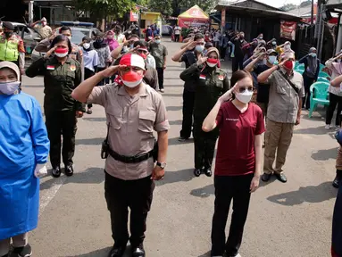 Ratusan masyarakat yang mengikuti vaksin Covid-19 memberi hormat saat memperingati HUT ke-76 RI di Jakarta, Selasa (17/8/2021). Hal tersebut dilakukan untuk mengenang jasa para pahlawan dalam memperjuangkan Kemerdekan Republik Indonesia. (Liputan6.com/Angga Yuniar)