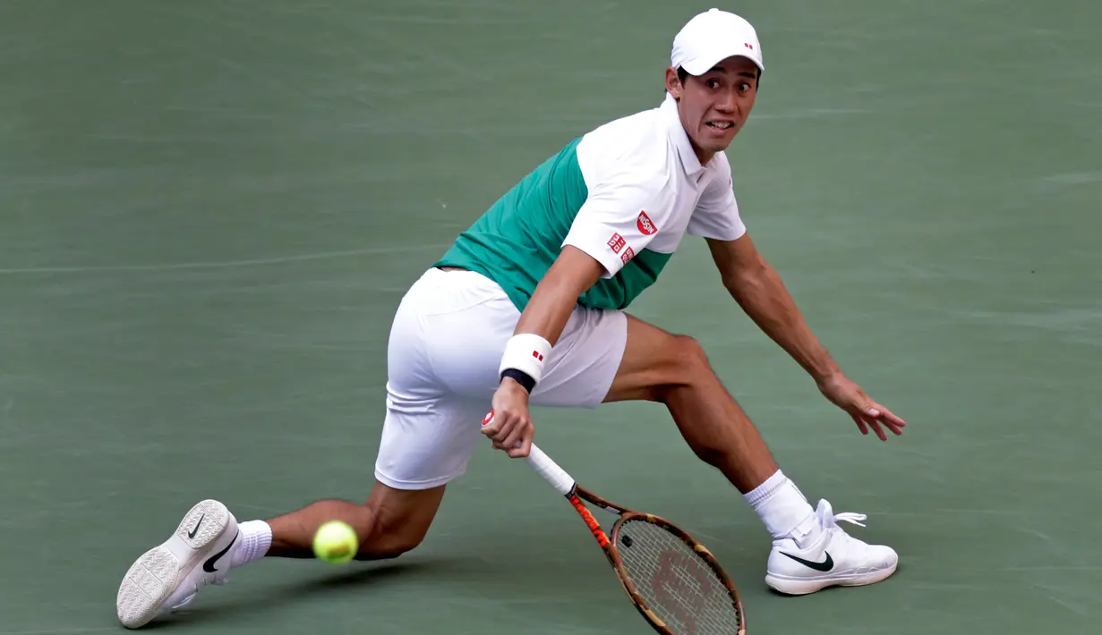 Petenis Jepang, Kei Nishikori mengembalikan bola ke arah Marin Cilic dari Kroasia pada perempat final turnamen tenis AS Terbuka di New York, Rabu (5/9). Pertandingan Nishikori versus Cilic berlangsung ketat selama lebih dari empat jam. (AP/Adam Hunger)