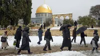 Sekelompok orang Yahudi mengunjungi Temple Mount yang dikenal oleh umat Islam sebagai Noble Sanctuary di Kompleks Masjid Al-Aqsa, Kota Tua Yerusalem, 27 Januari 2022. Hujan salju yang jarang melanda sebagian wilayah Israel dan Tepi Barat telah menutup sekolah dan bisnis. (AP Photo/Mahmoud Illean)