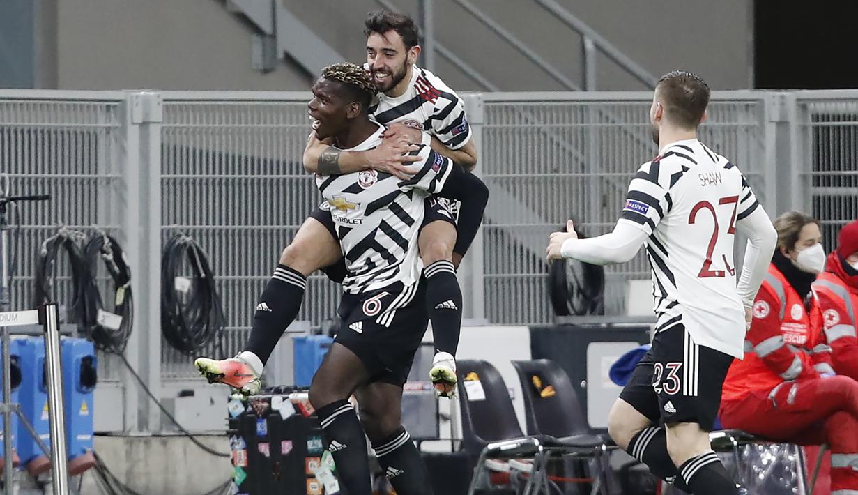 Gelandang Manchester United, Paul Pogba bersama Bruno Fernandes merayakan gol yang dicetaknya ke gawang AC Milan dalam laga leg kedua babak 16 besar Liga Europa 2020/2021 di San Siro Stadium, Milan, Kamis (18/3/2021). Manchester United menang 1-0 atas AC Milan. (AP/Antonio Calanni)