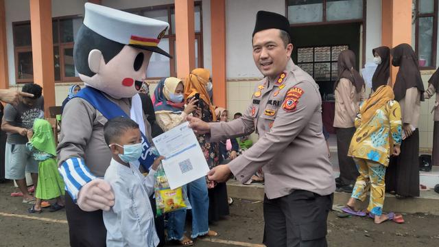 Kapolres Tasikmalaya AKBP Rimsyahtono berfoto bersama maskot tertib berlalu lintas dengan anak-anak usia 6-11 tahun peserta vaksinasi Covid-19.