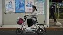 Seorang wanita melewati fasilitas pengujian virus corona yang memajang poster yang mempromosikan vaksinasi COVID-19 di Beijing, Rabu (26/10/2022). Kota Shanghai di China mulai memberikan vaksin COVID-19 yang dapat dihirup pada hari Rabu di tempat yang tampaknya menjadi yang pertama di dunia. (AP Photo/Andy Wong)