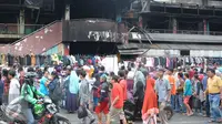 Para pedagang menjajakan dagangannya di depan gedung Pasar Senen pasca kebakaran, Jakarta, Minggu (22/1). Karena akhir pekan pengunjung justru tumpah ruah di Pasar Senen untuk memilah baju bekas. (Liputan6.com/Helmi Affandi)