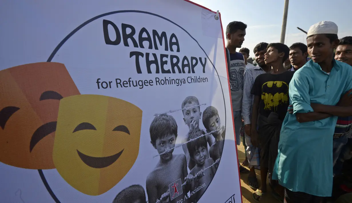 Sejumlah pengungsi Rohingya menonton hiburan dari kelompok teater Drama Therapy di kamp pengungsi Kutupalong, Bangladesh (28/10). (AFP Photo/Tauseef Mustafa)