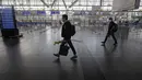 Beberapa penumpang berjalan di dalam bandara internasional Arturo Merino Benitez yang sepi pada hari pertama pemerintah menutup perbatasan di Santiago, Chile, Senin (5/4/2021). Kasus COVID-19 telah melonjak di Chile meskipun ada upaya vaksinasi. (AP Photo/Esteban Felix)