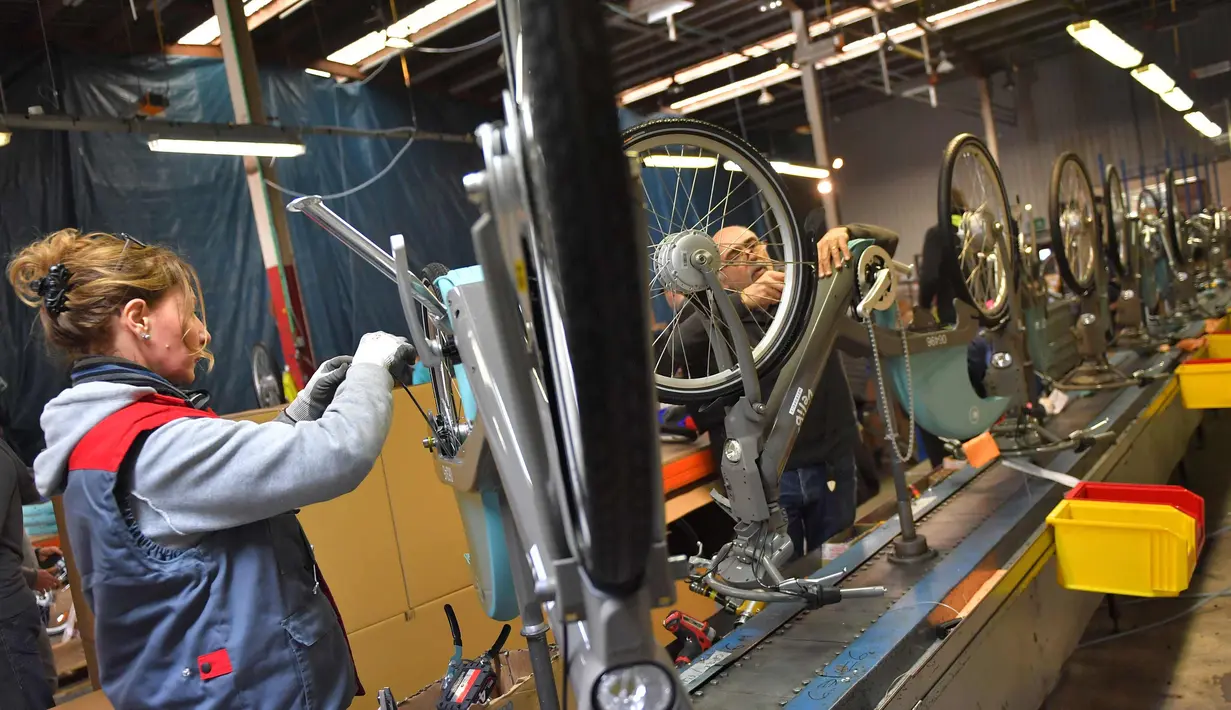 Seorang pekerja mengecek sepeda listrik Velib di pabrik Arcade Cycle di Paris, Prancis, (19/12). Sepeda yang dibuat dipabrik ini untuk disewakan di kota-kota di seluruh dunia khususnya di Prancis. (AFP Photo/Loic Venance)