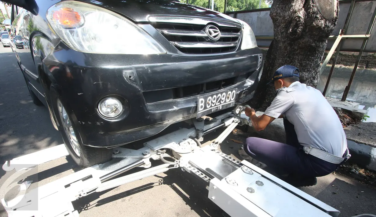 Petugas Dishub memasang alat derek ke kendaraan yang parkir liar di kawasan Pasar Baru, Jakarta, Kamis (7/1). Pemprov DKI berencana menaikan denda Rp 3 juta per hari terhadap kendaraan yang terjaring parkir liar. (Liputan6.com/Immanuel Antonius)