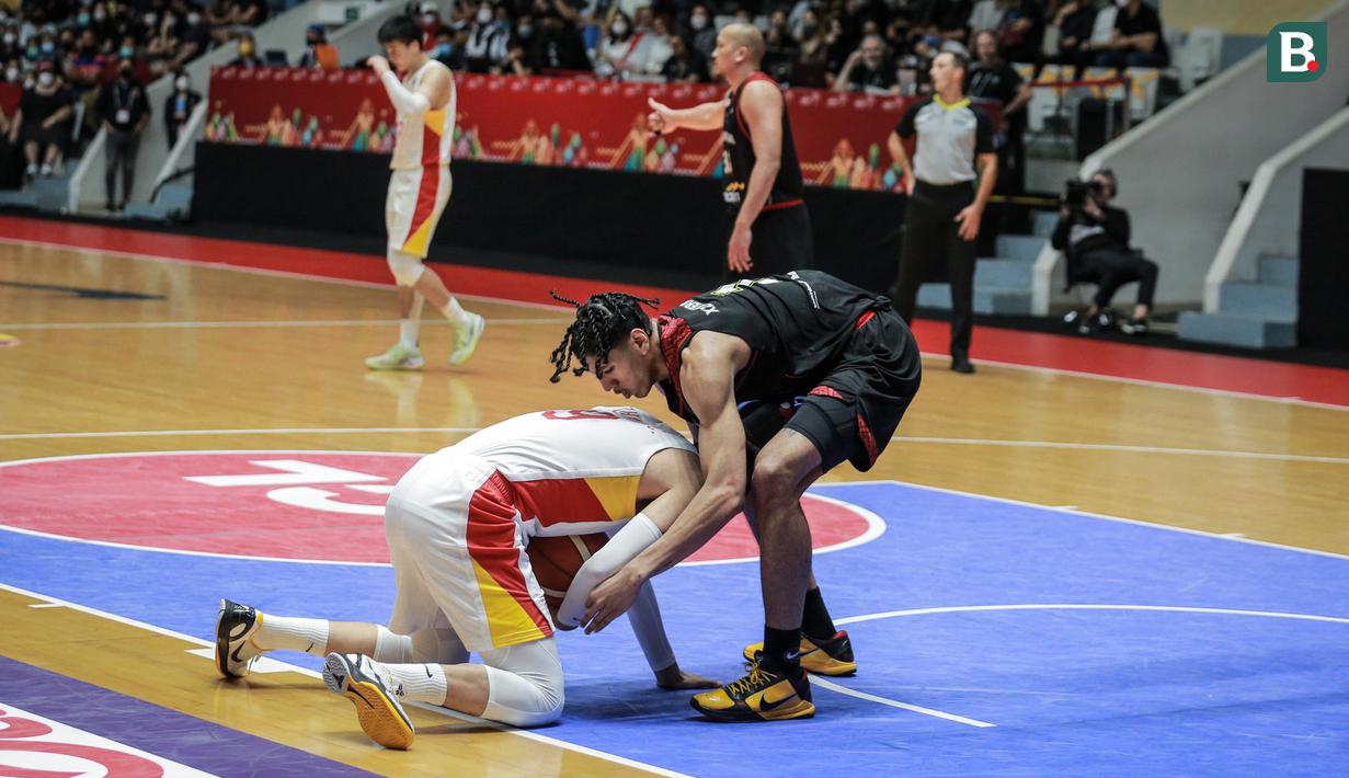 Pemain Timnas Basket Indonesia, Derrick Michael Xzavierro (kanan) berusaha merebut bola pemain Timnas Basket China, Zhai Xiaochuan saat laga playoff perempat final FIBA Asia Cup 2022 di Istora Senayan, Jakarta, Senin (18/07/2022). (Bola.com/Bagaskara Lazuardi)