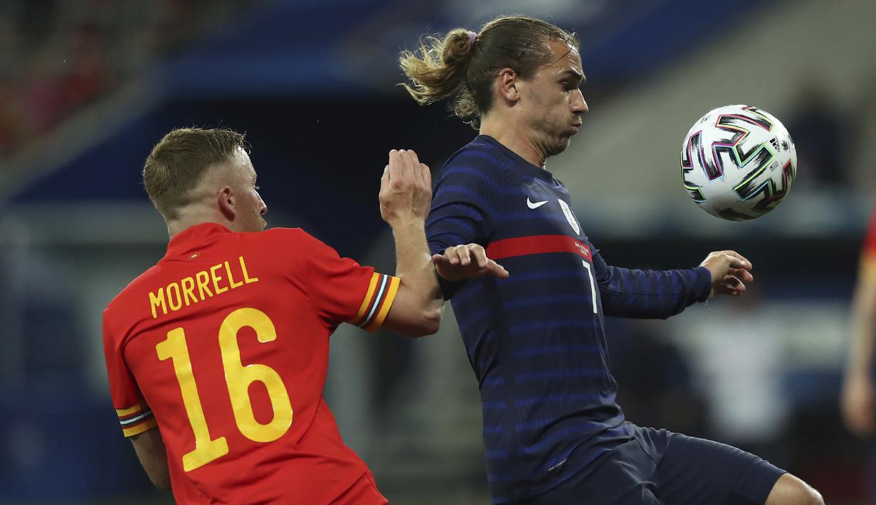 Striker Prancis, Antoine Griezmann (kanan) menguasai bola dibayangi gelandang Wales, Joe Morrell dalam laga uji coba menjelang berlangsungnya Euro 2020 di Allianz Riviera Stadium, Nice, Rabu (2/6/2021). Prancis menang 3-0 atas Wales. (AP/Daniel Cole)