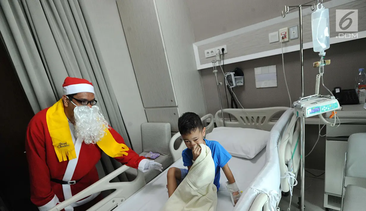 Seorang pria mengenakan kostum Santa Claus berbincang dengan pasien anak yang dirawat di RS Siloam, TB Simatupang, Jakarta, Kamis (21/12). Kegiatan ini dalam rangka menyambut perayaan Hari Natal 2017. (Liputan6.com/Joan)