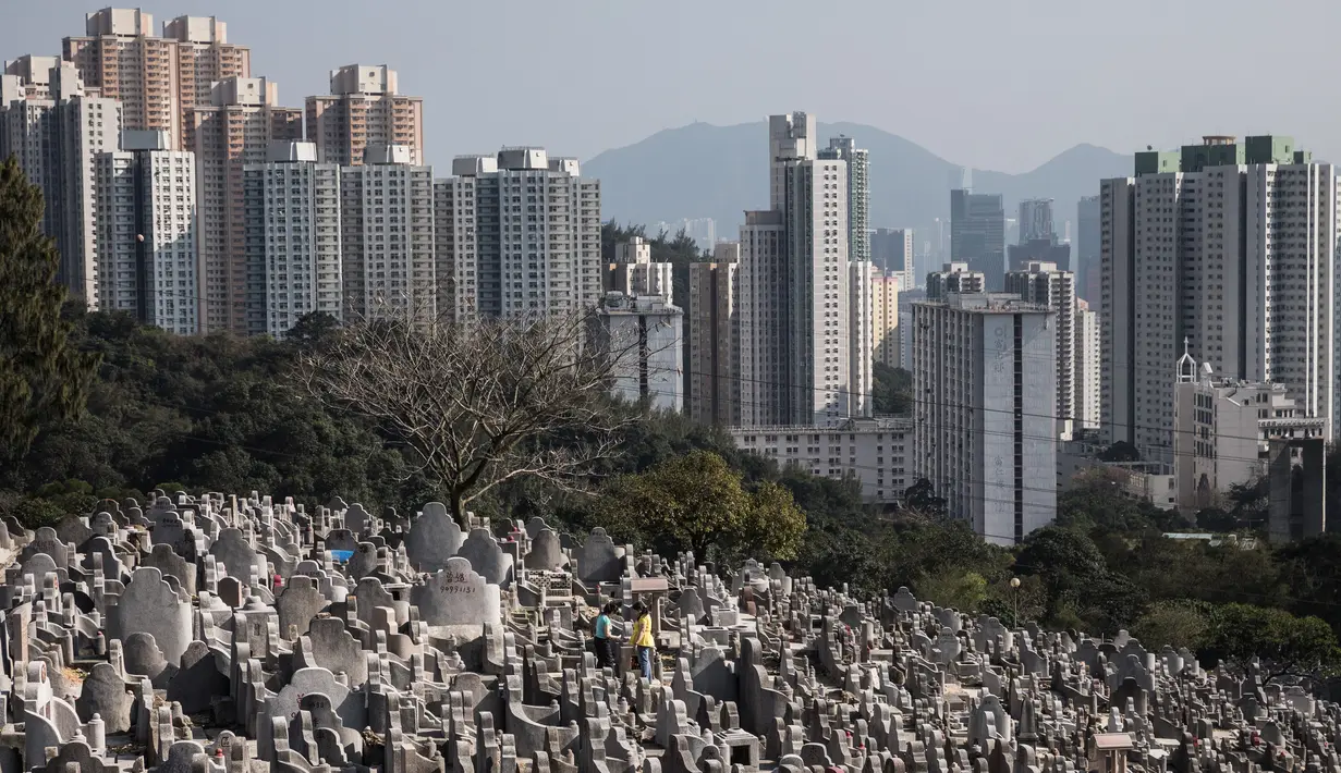 Dua orang wanita berdoa memberikan penghormatan di depan makam keluargnya untuk menyambut festival Ching Ming dikomplek pemakaman di Hong Kong (2/4). (AFP/Dale De La Rey)