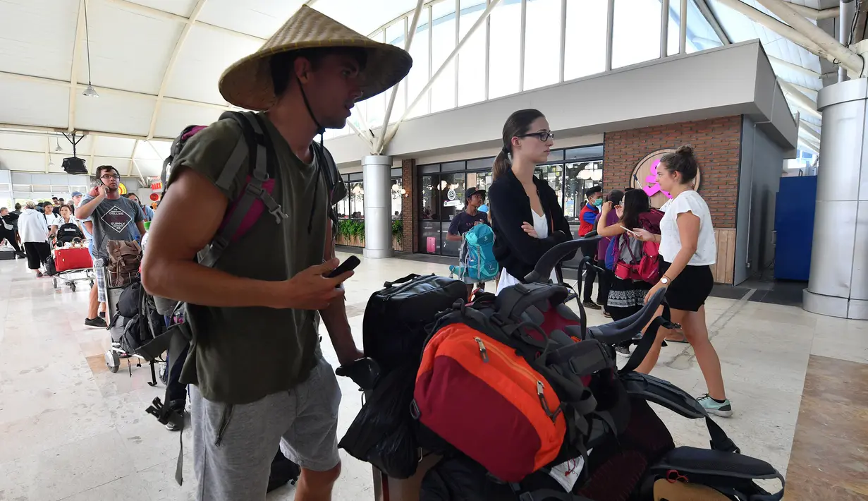 Wisatawan antre memasuki terminal keberangkatan Bandara Lombok Praya di pulau Lombok, NTB, Senin (6/8). BNPB melaporkan Bandara Lombok Praya pada pagi ini menjalani aktivitas seperti biasa setelah gempa dahsyat berkekuatan 7,0 SR. (AFP/Adek BERRY)