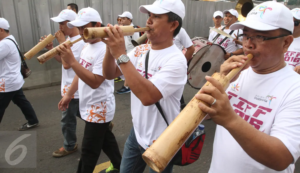 Peserta memainkan alat musik tradisional saat mengikuti pawai Tomohon International Flower Festival di Jakarta, (29/5/2016). Tomohon International Flower Festifal (TIFF) berlangsung pada 8 Agustus mendatang. (Liputan6.com/Herman Zakharia)