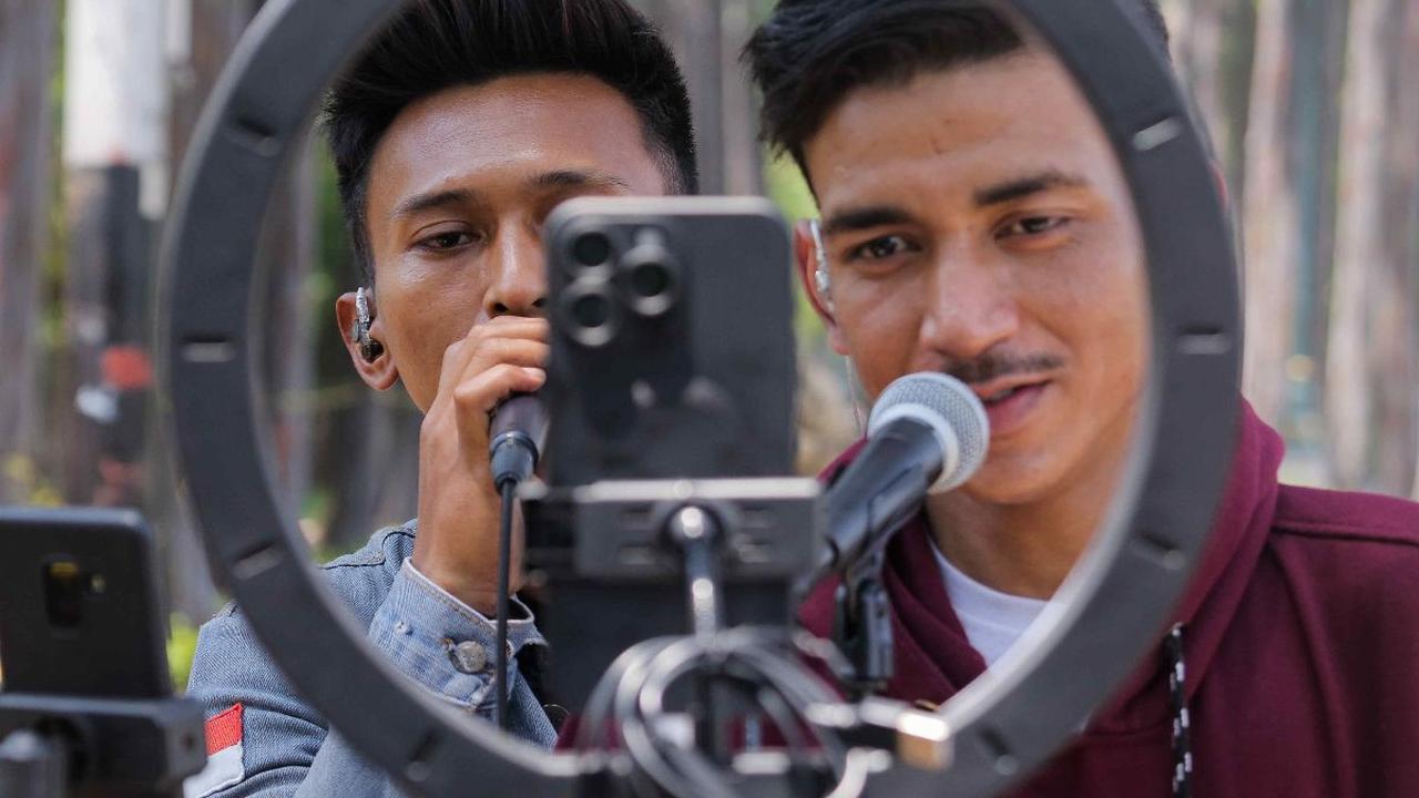 Kreator konten TikTok bernyanyi saat melakukan live straming di kawasan Kanal Banjir Timur (KBT), Duren Sawit, Jakarta Timur, Sabtu (7/9/2024). Kawasan Kanal Banjir Timur yang teduh karena rindangnya pepohonan kini diramaikan dengan kreator TikTok yang me