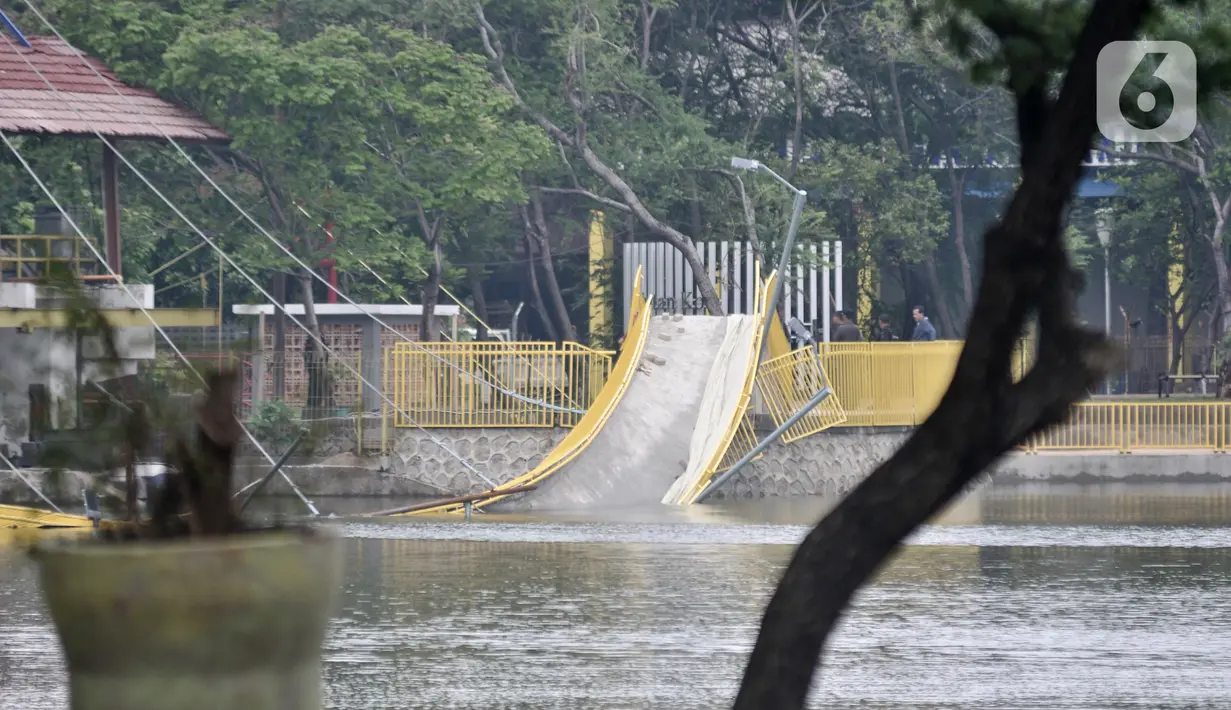 Pihak PPK Kemayoran memeriksa jembatan ambruk di Hutan Kota Kemayoran, Jakarta, Minggu (22/12/2019). Sebelumnya jembatan yang berfungsi sebagai viewing deck ini merupakan salah satu fasilitas hutan kota yang baru diresmikan pihak Pusat PPK Kemayoran pada (21/12/2019). (Merdeka.com/Iqbal S. Nugroho)