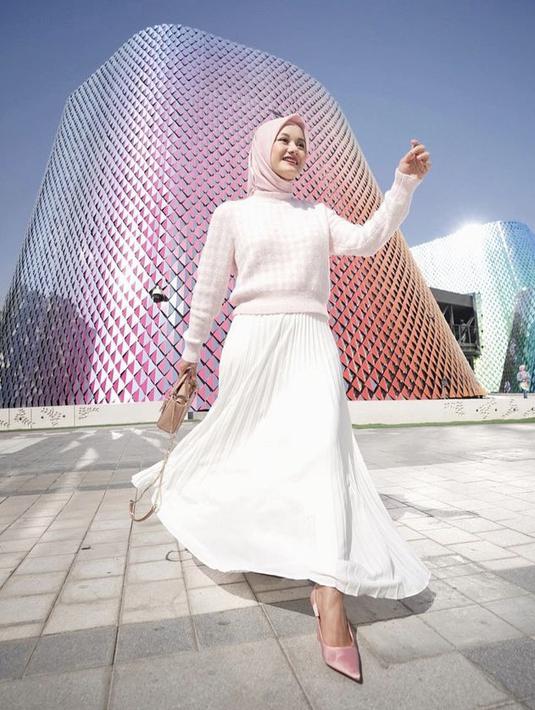 <p>Dinda Hauw kerap kali mengenakan pakaian berunsur warna pastel, seperti sweater pink bermotif yang serasi dengan warna hijabnya. Dikombinasikan long skirt plisket warna putih, dan stiletto pink. @dindahw</p>