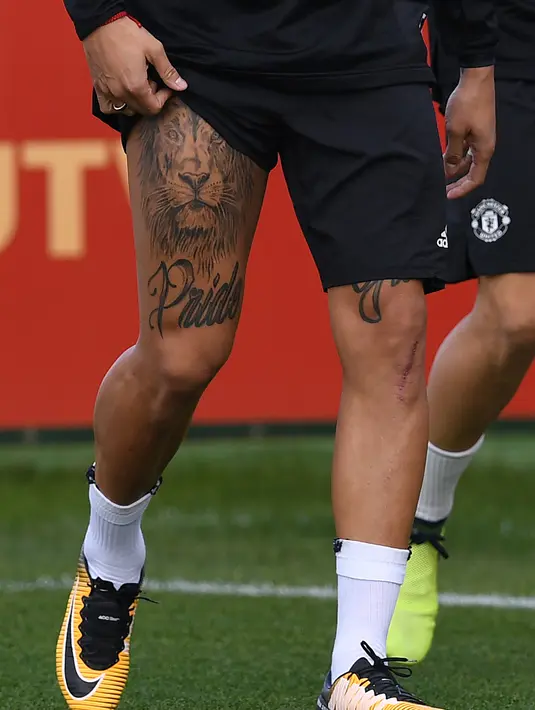 Marcos Rojo menunjukan tato Singa miliknya saat mengikuti sesi latihan di club training complex, Carrington, Manchester, (11/9/2017). MU akan melawan FC Basel di grup A Liga Champions. (AFP/Paul Ellis)