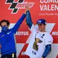 Pembalap Suzuki Ecstar, Joan Mir (kanan) merayakannya dengan Manajer Tim Davide Brivio setelah memenangkan kejuaraan dunia MotoGP setelah Grand Prix Valencia di sirkuit Ricardo Tormo di Valencia  (15/11/2020). (AFP/Lluis Gen)