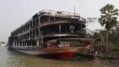 Kapal feri yang terbakar terlihat berlabuh di pantai Jhalkathi, Bangladesh, Jumat (24/12/2021). Kebakaran kapal feri tersebut menewaskan 37 orang. (ARIFUR RAHMAN/AFP)