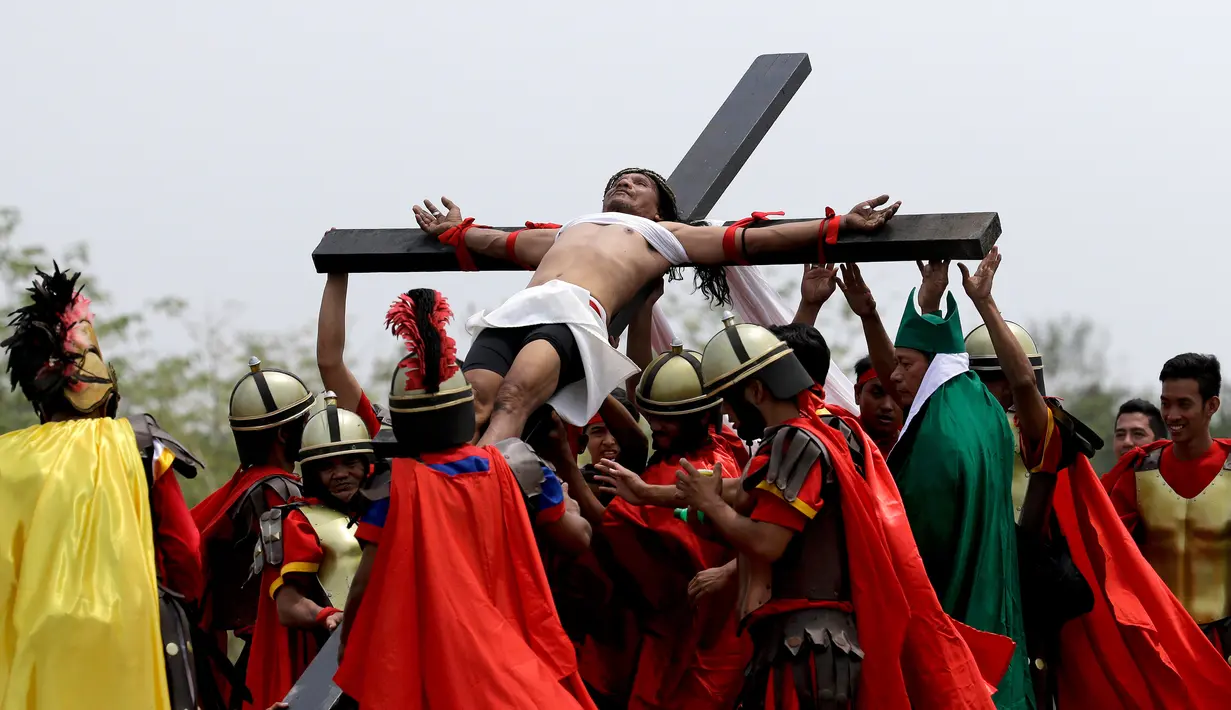 Suasana penyaliban Ruben Enaje dalam rangka visualisasi penderitaan Yesus Kristus di Pampanga, Filipina, Jumat (30/3). Ribuan ini dihadiri ribuan orang. Ribuan orang menghadiri penyaliban ini. (AP Photo/Aaron Favila)