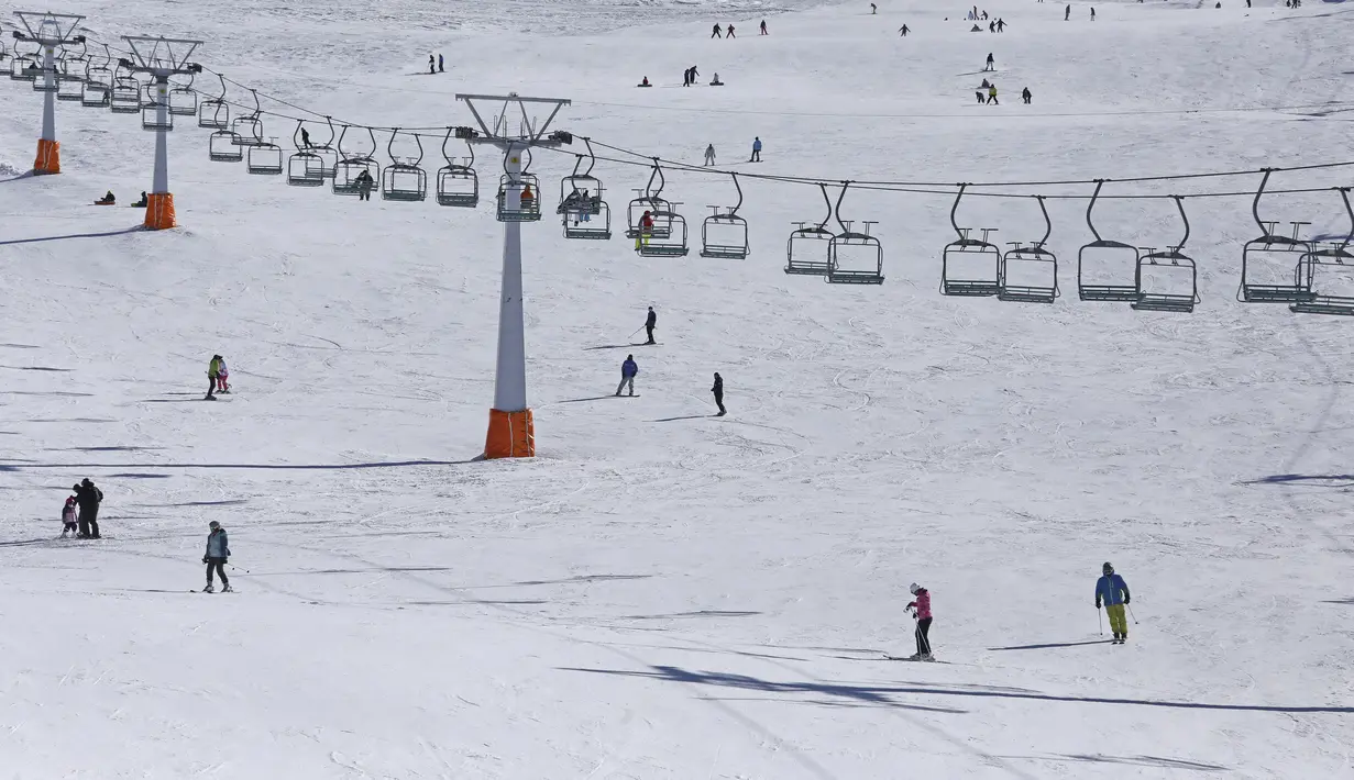 Pemain ski Iran menuruni lereng di resor ski Tochal di luar ibu kota Teheran, Iran (1/1/2022). Di tengah polusi udara dan kesengsaraan ekonomi, penduduk Teheran menemukan kenyamanan di resor ski di utara Teheran di pegunungan Alborz. (AP Photo/Vahid Salemi)