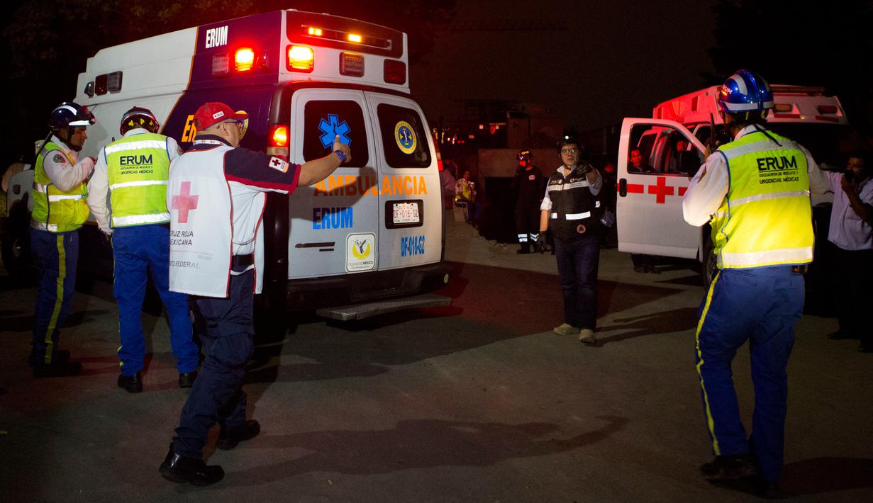 Petugas medis bersiap mengevakuasi korban garasi parkir bawah tanah yang runtuh di sebuah kompleks di Mexico City (10/4). Akibat insiden tersebut, sejumlah orang tewas dan masih terjebak di dalam. (AP Photo/Rebecca Blackwell)