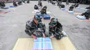 Tentara (kiri) mengajari mahasiswa baru melipat selimut selama sesi pelatihan militer di sebuah kampus di Yangzhou, Jiangsu, China, Jumat (6/9/2019). China memilih pelatihan militer atau dikenal dengan istilah 'Junxun' sebagai program orientasi mahasiswa baru. (STR/AFP)