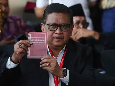Tersangka kasus dugaan suap pergantian antarwaktu (PAW) dan perintangan penyidikan, Hasto Kristiyanto menunjukkan buku tentang Hak dan Kewajiban Tersangka/Terdakwa Tindak Pidana Korupsi sesaat sebelum menjalani pemeriksaan oleh penyidik Komisi Pemberantasan Korupsi (KPK) di Gedung Merah Putih KPK, Jakarta, Senin (13/1/2025). (Liputan6.com/Angga Yuniar)