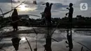 Anak-anak bermain layang terlihat dari refleksi air Waduk Kampung Rambutan 2, Jakarta, Kamis (12/11/2020). Beragam kegiatan seperti olahraga, memancing, dan bermain layang-layang menjadi pemandangan di waduk ini saat sore hari. (merdeka.com/Iqbal S. Nugroho)
