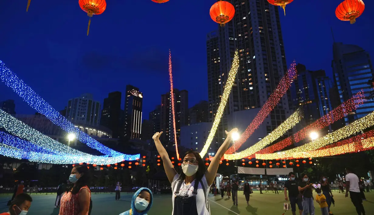 Orang-orang foto di depan dekorasi selama Festival Pertengahan Musim Gugur di taman Victoria di Hong Kong, Selasa (21/9/2021).  Festival ini didatangi keluarga dan teman Tionghoa untuk berkumpul makan kue bulan China dan pomelo bersama-sama. (AP Photo/Vincent Yu)
