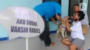 Warga melakukan vaksinasi rabies pada hewan peliharaannya saat kegiatan Vaksinasi Rabies Massal Gratis se-Kota Depok di Kantor kecamatan Cinere, Depok, Jawa Barat, Sabtu (18/11/2023). (merdeka.com/ Arie Basuki)