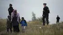 Petugas polisi berpatroli di dekat kamp migran di Calais, Prancis pada 14 Oktober 2021. Dalam praktik berbahaya dan berpotensi mematikan, beberapa imigran mencoba melewati terowongan menuju Inggris yang dijaga ketat yang menghubungkan kedua negara dengan bersembunyi di truk. (AP/Christophe Ena)