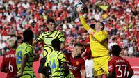 Kiper Manchester United, Tom Heaton berhasil meninju bola hasil sundulan gelandang Arsenal, Kai Havertz pada laga pramusim 2023/2024 di MetLife Stadium, New Jersey, USA, Minggu (23/7/2023) pagi WIB. (AFP/Getty Images/Rich Schultz)