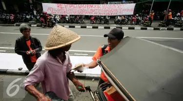 Juru parkir melakukan aksi dengan membagikan nasi bungkus di Jalan Malioboro,Yogyakarta, Jumat (11/3). Dalam aksinya mereka meminta dukungan kepada pengguna jalan yang melintas dan menuntut kejelasan relokasi yang bernurani. (Liputan6.com/Boy Harjanto)