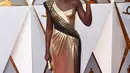 Aktris Lupita Nyong'o berpose di karpet merah ajang Piala Oscar 2018, Los Angeles, Minggu (4/3). Pemeran Nakia dari Black Phanter ini tampil mewah dalam balutan dress emas-hitam berkilau dari Atelier Versace. (Jordan Strauss/Invision/AP)