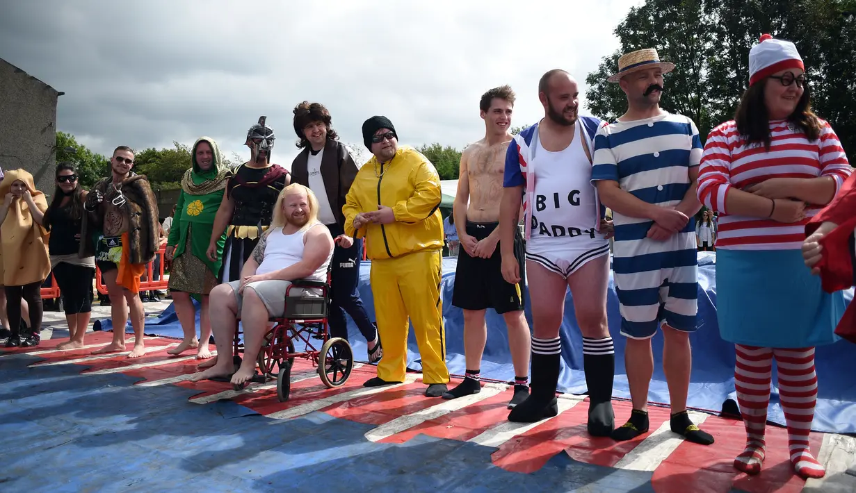 Peserta gulat mengenakan kostum unik bersiap mengikuti World Gravy Wrestling Championships ke-10 di Rose 'n' Bowl Pub di Inggris (28/8). Pertandingan gulat ini cukup unik, karena digelar di sebuah kolam selam dua menit. (AFP Photo/Oli Scarff)