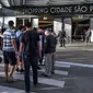 Antrean pengunjung memasuki pusat perbelanjaan yang kembali dibuka di Paulista Avenue, Sao Paulo, Kamis (11/6/2020). Kota terpadat di Brasil, Sao Paulo telah mengizinkan pertokoan dan pusat perbelanjaan kembali beroperasi ketika jumlah kasus Covid-19 di kota itu masih tinggi. (NELSON ALMEIDA/AFP)