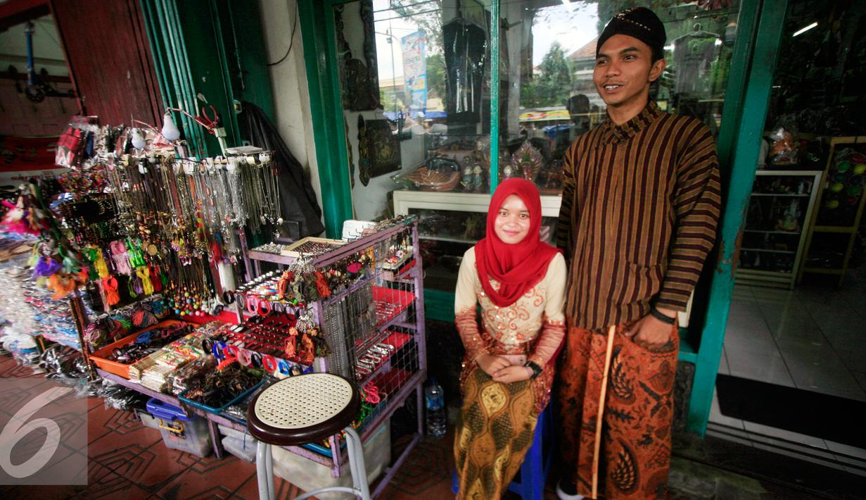 PKL wanita dan pria berpose di emperan toko kawasan Malioboro mengenakan pakaian tradisional, Rabu (20/4/2016). Sejumlah PKL mengenakan pakain adat jawa menyambut hari Kartini 21 April besuk. (Liputan6.com/Boy Harjanto)