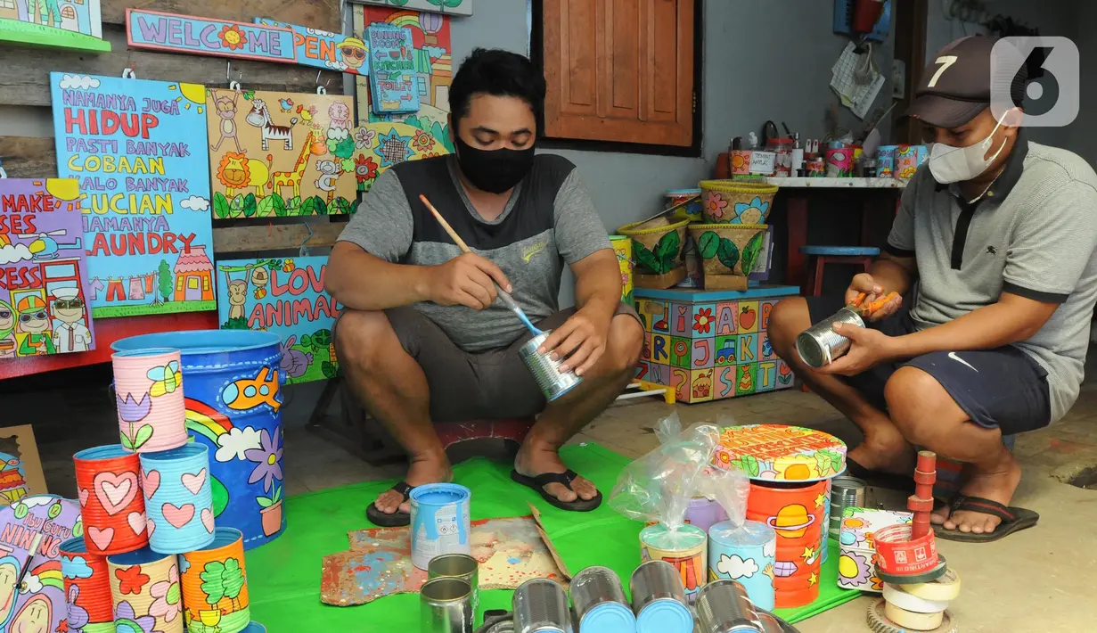 Perajin melukis bahan daur ulang untuk dipasarkan secara online di Kaleng Lani  di kawasan Tanah Baru, Depok, Jawa Barat, Rabu (9/3/2022). Beragam kerajinan tangan seperti celengan, tempat pensil, tempat sampah, dan lain-lain terbuat dari kayu dan kaleng bekas. (merdeka.com/Arie Basuki)