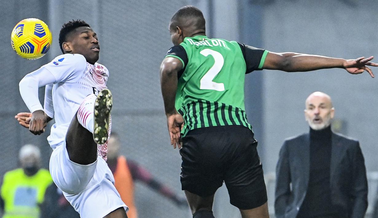 Penyerang AC Milan, Rafael Leao, berebut bola dengan pemain Sassuolo, Marlon, pada laga Liga Italia di Stadion Mapei, Minggu (20/12/2020). AC Milan menang dengan skor 2-1. (Alberto Pizzoli/AFP)