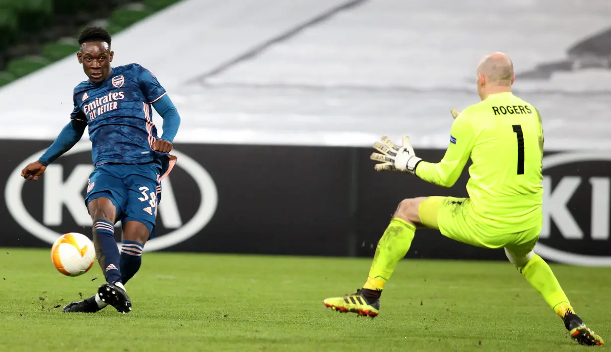 Striker Arsenal, Folarin Balogun (kiri) mencetak gol ke gawang Dundalk selama pertandingan Grup B Liga Europa 2020/2021 di Stadion Aviva, Jumat (11/12/2020) dini hari WIB. Arsenal menang 4-2 saat bertandang di markas wakil Irlandia, Dundalk. (Paul Faith / AFP)