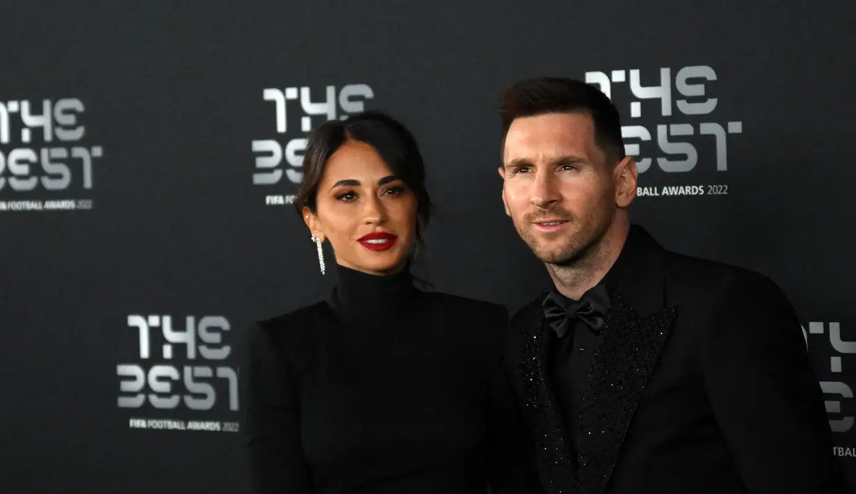 Pemain Paris Saint-Germain asal Argentina, Lionel Messi (kanan) dan istrinya Antonela Roccuzzo berpose setibanya pada acara The Best FIFA Football Awards 2022 di Paris, Prancis, 27 Februari 2023. Keduanya tampak mengumbar kemesraan sepanjang acara. (FRANCK FIFE/AFP)
