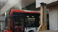 Beredar sebuah video yang memperlihatkan bus Transjakarta, Metrotrans tersangkut dan mengeluarkan asap dari bagian atas bu (Istimewa)